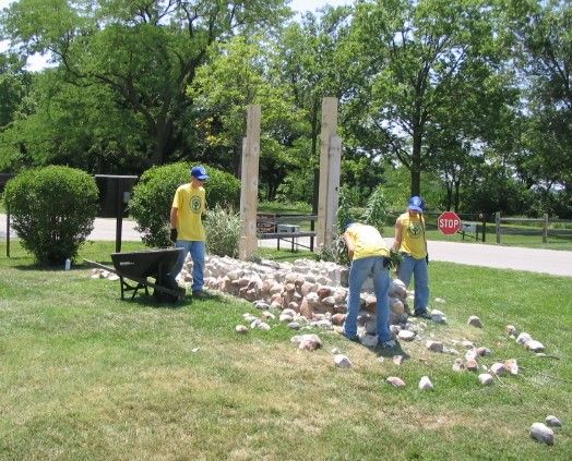 Three YCC workers working on old sign base demolition at HOME visitor center.