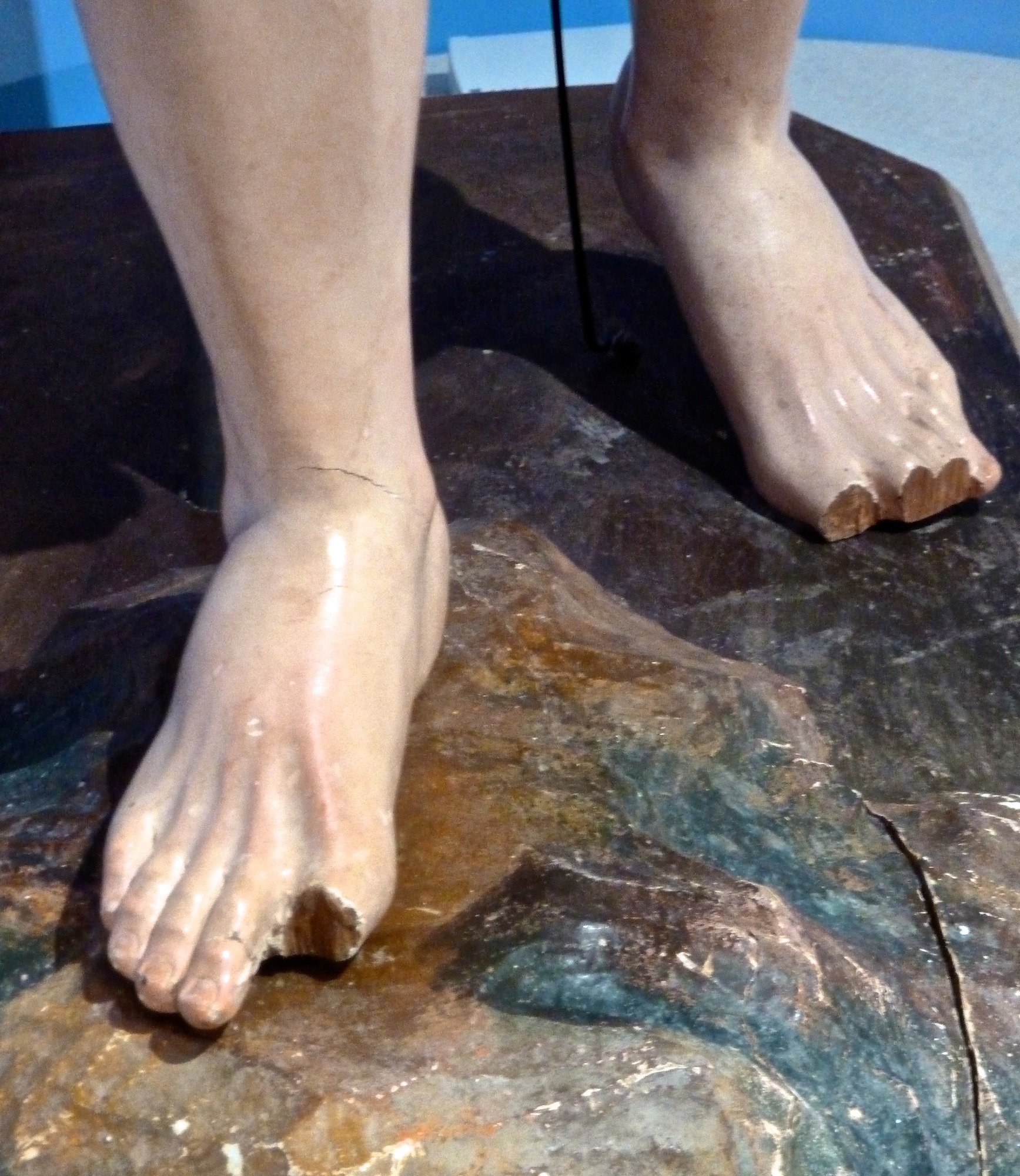closeup of wooden carved statue feet