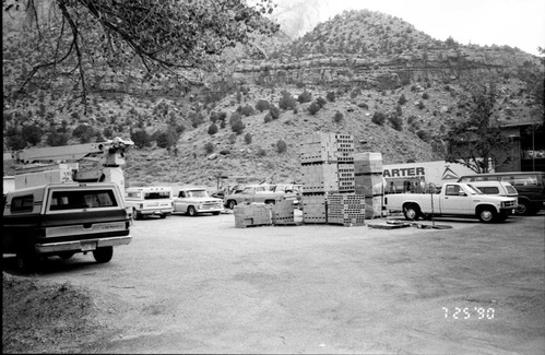 Parking lot with construction vehicles and building materials during the construction of headquarters addition.
