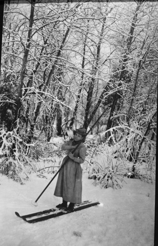 Copy Neg: Leroy Radanovich, September 1998. Nellie Atkinson, on Norwegian snowshoes with cat on her shoulders. Title "Maxie's Snow Shoe Ride". Also YOSE 5260 and YOSE 18191.