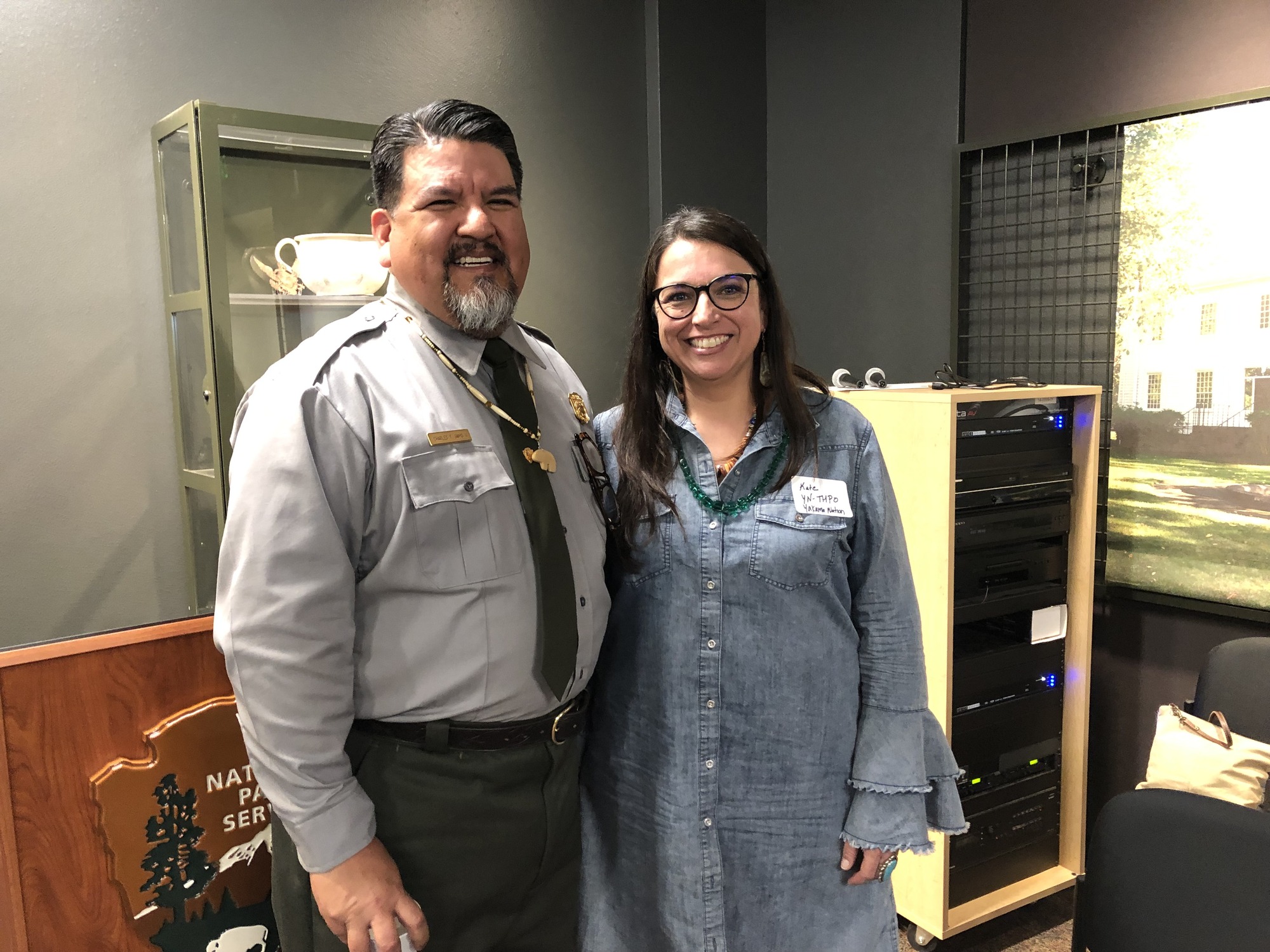 NPS Director Sams in a NPS uniform poses with a woman in the Fort Vancouver Visitor Center.