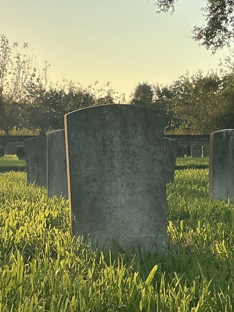 Back of historic upright marble headstone with recessed shield face.