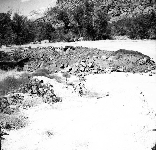 Amount of debris collected first day after flood. Material stockpiled for road construction. [One of two images on single strip of film. See also ZION 8581 frame 2.]
