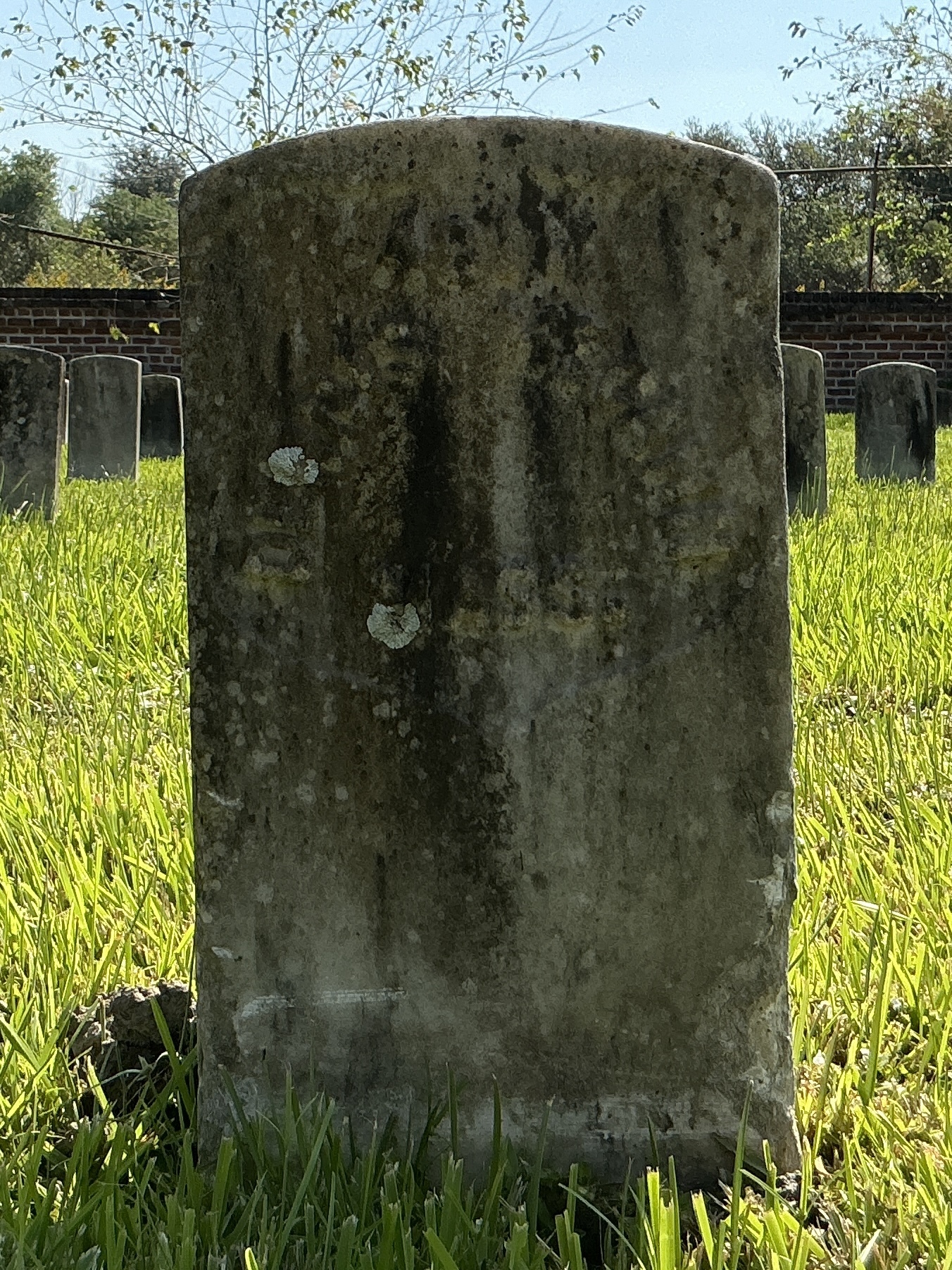 Front of historic upright marble headstone with recessed shield face.