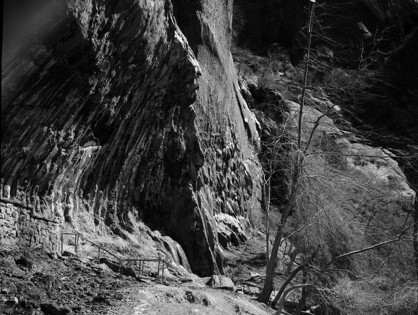 Weeping Rock. Handrail and rock wall masonry visible in foreground.