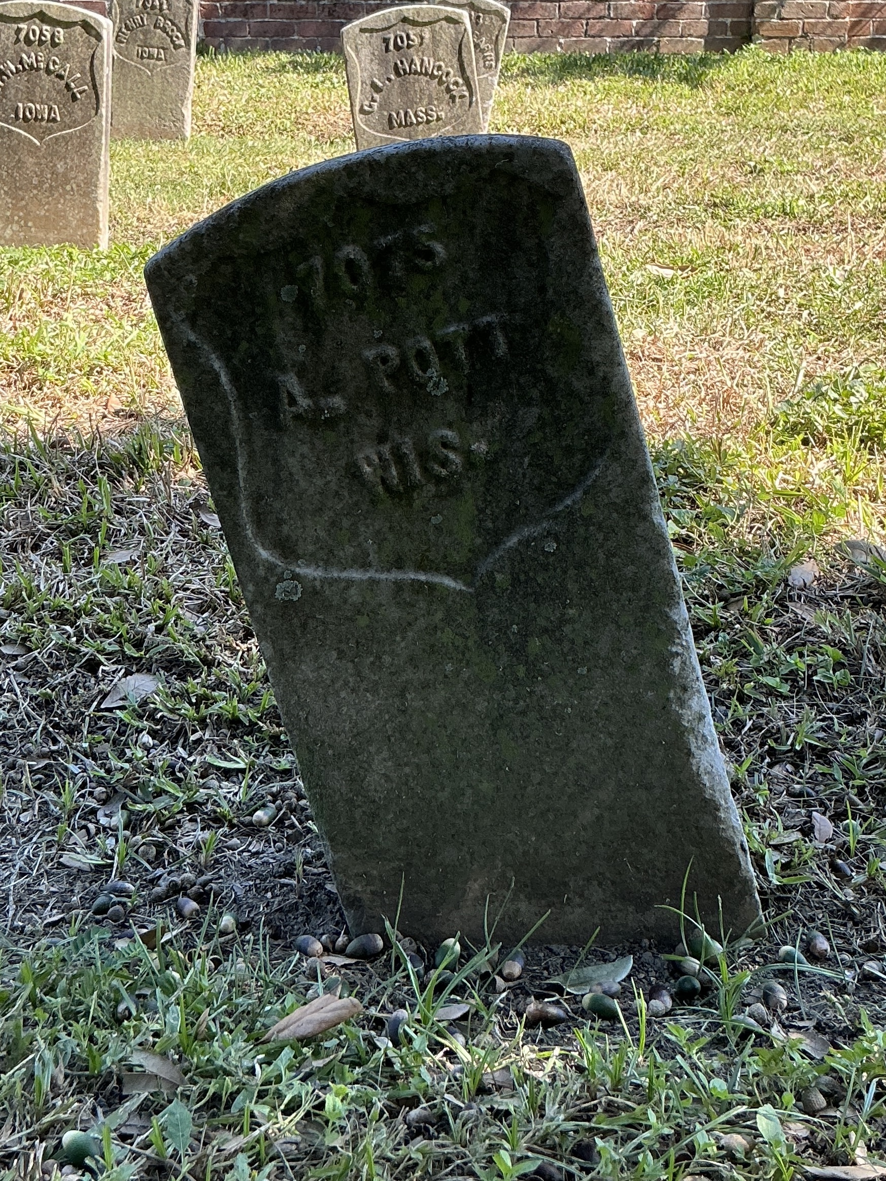 Front of historic upright marble headstone with recessed shield face.