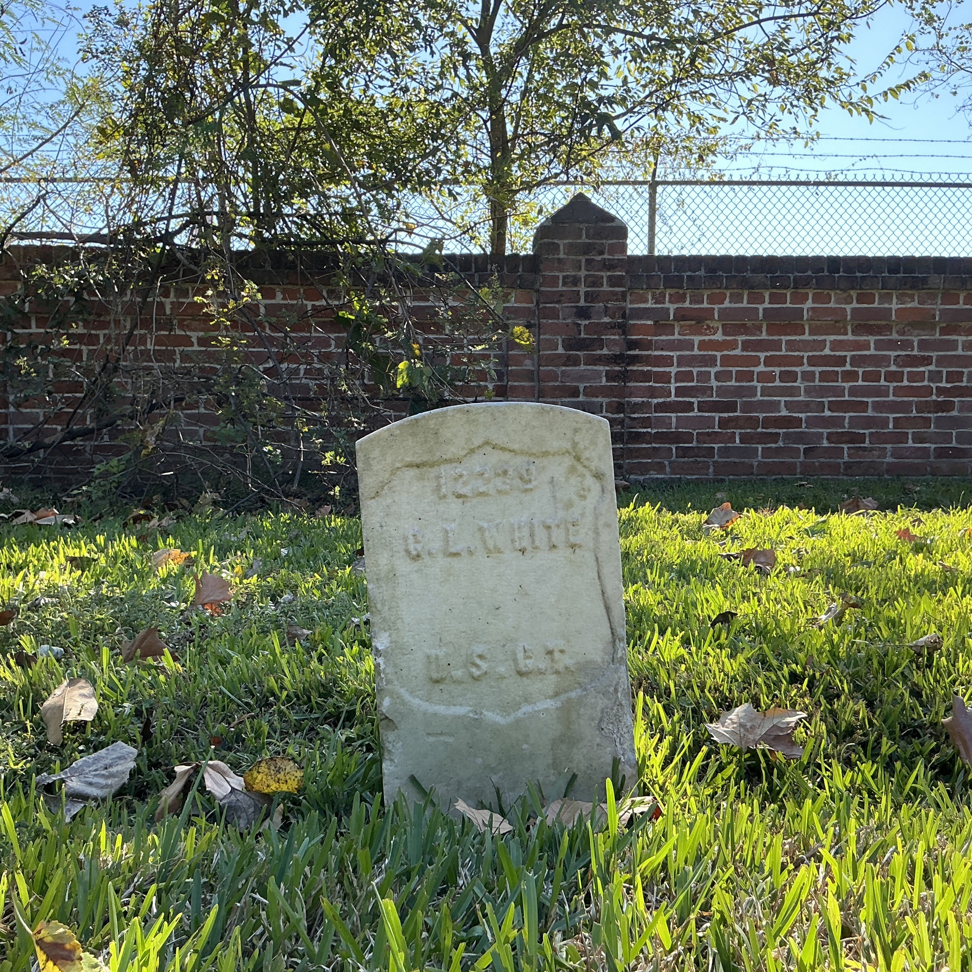 Front of historic upright marble headstone with recessed shield face.