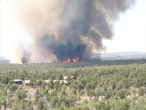 Full fire with black smoke advancing on buildings on the first day of Long Mesa Fire, Mesa Verde National Park, July 29, 2002