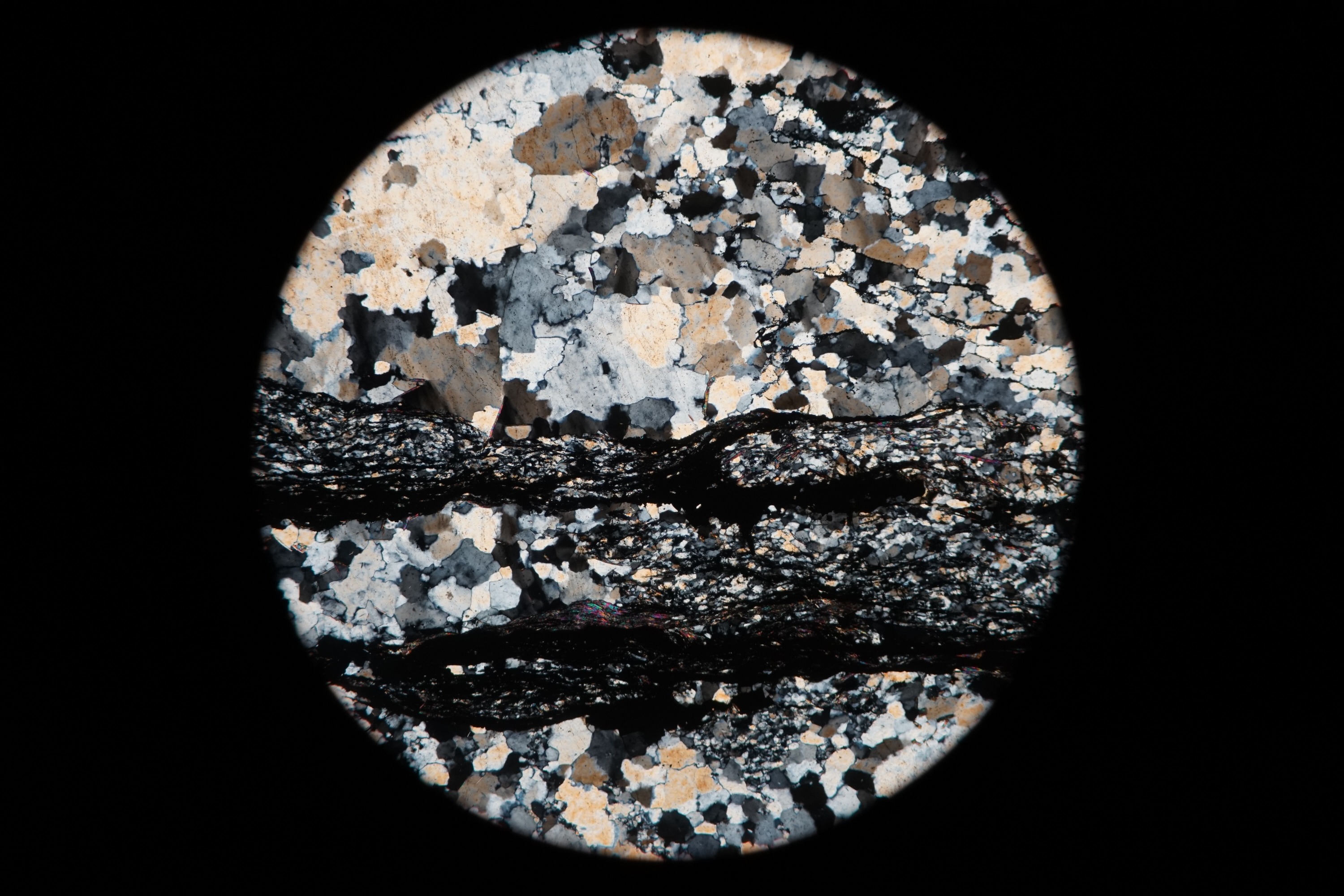 Circular microscopic image of rock structure.