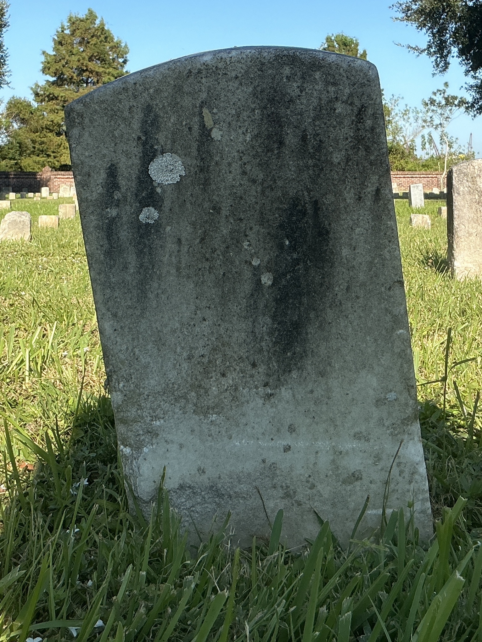 Back of historic upright marble headstone with recessed shield face.
