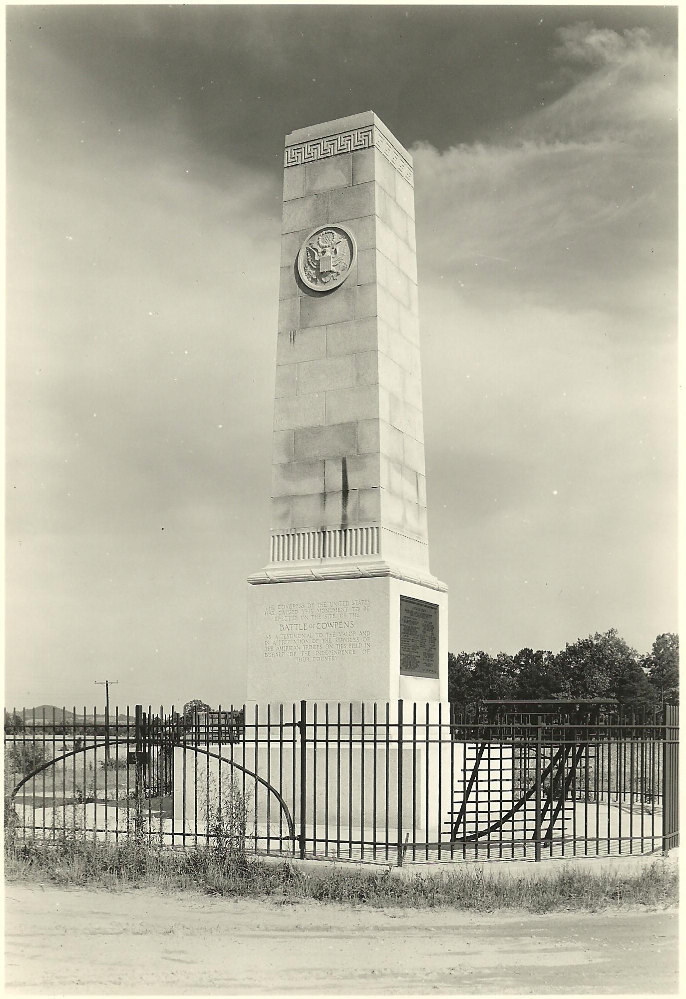 A granite obelisk surrounded by a black metal fence