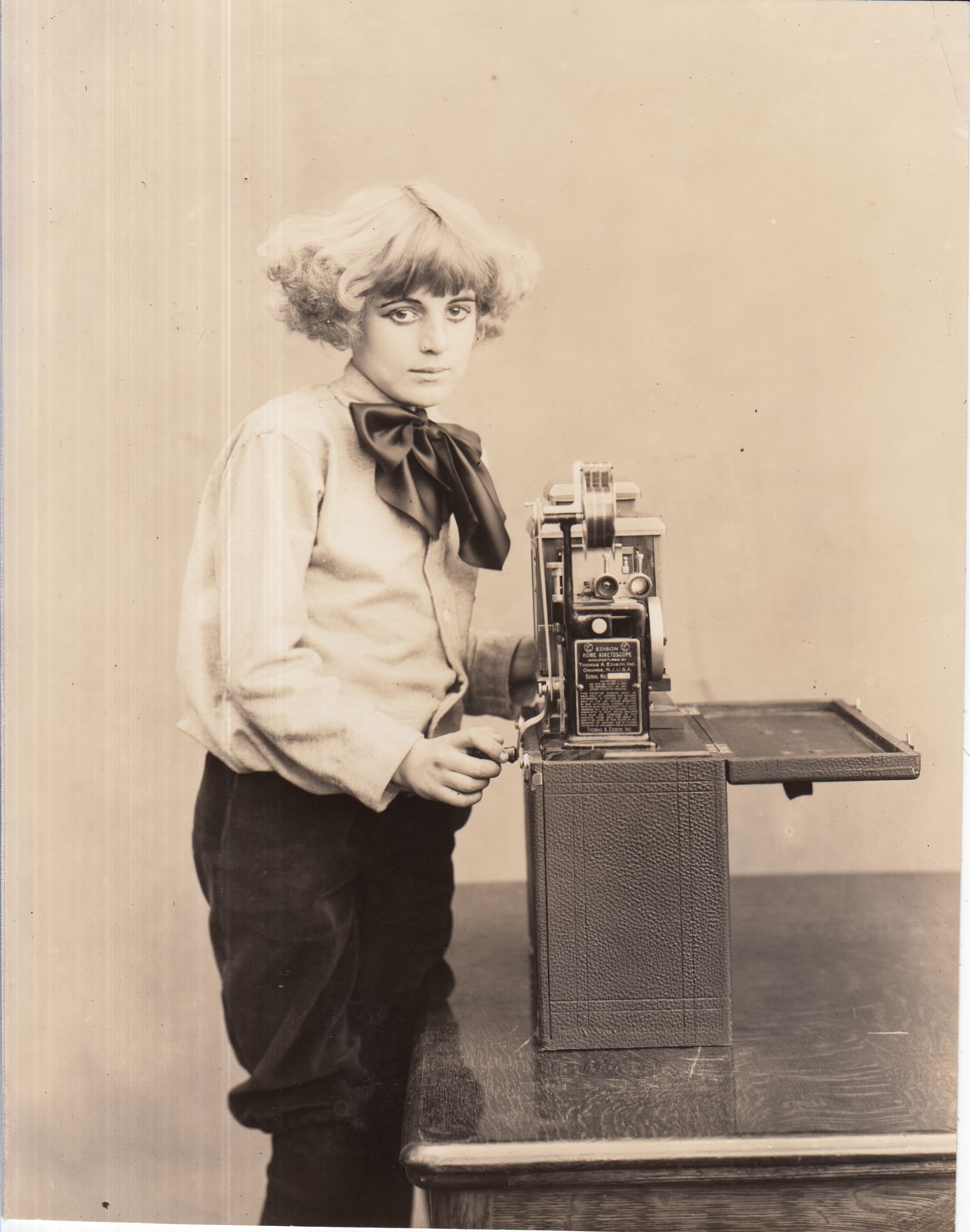Publicity shot, girl with Edison home projecting kinetoscope.