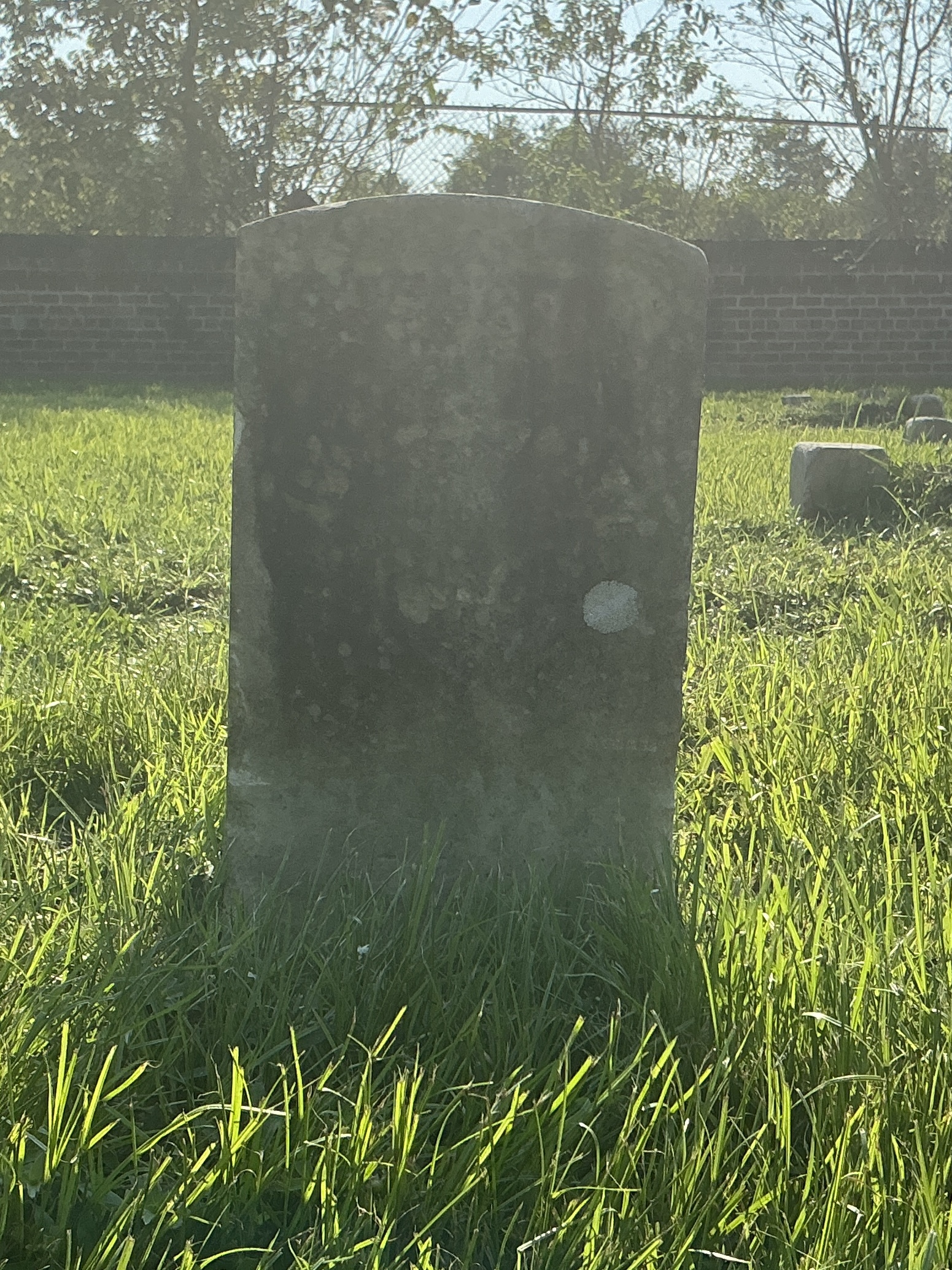 Front of historic upright marble headstone with recessed shield face.