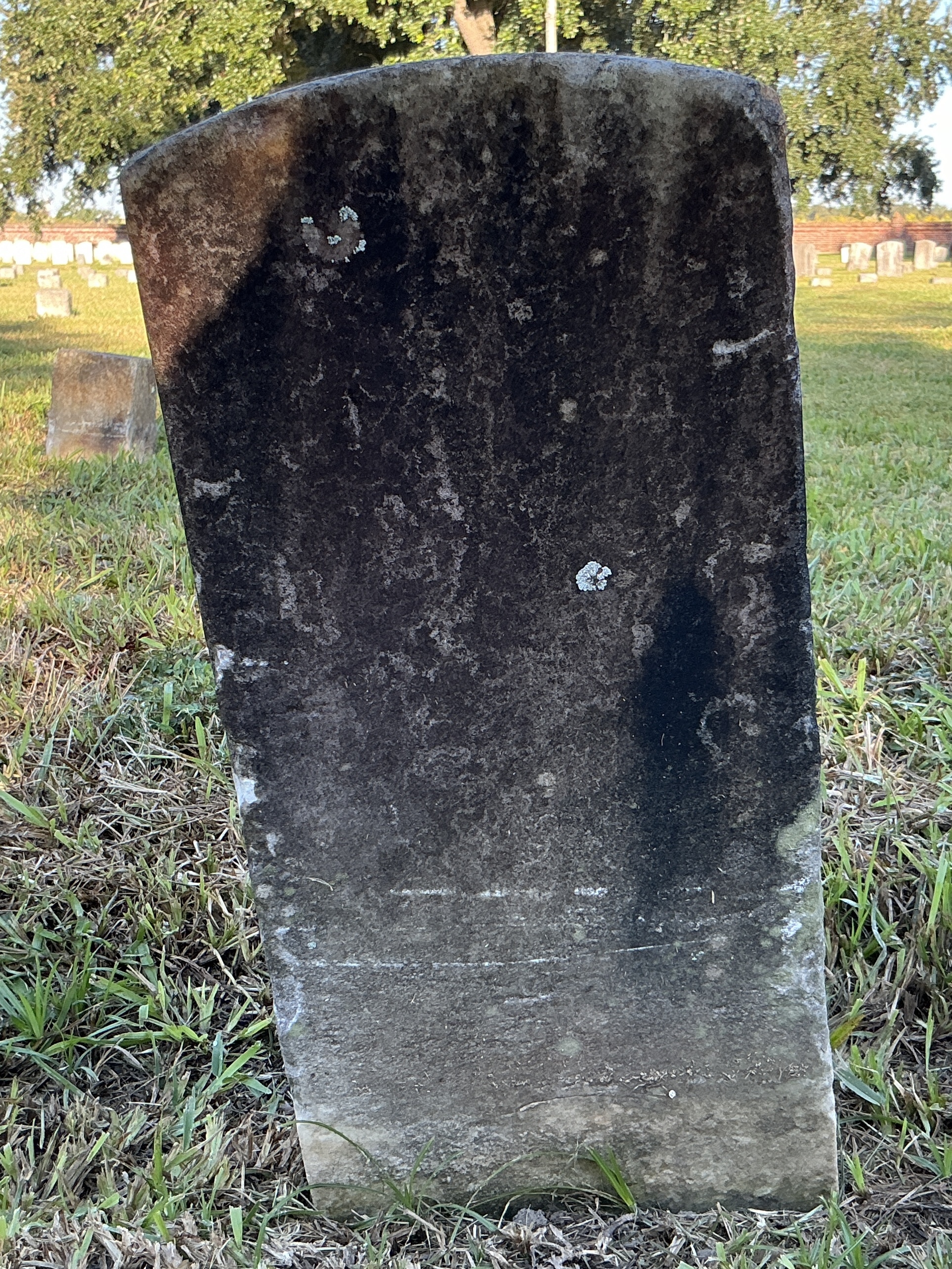Back of historic upright marble headstone with recessed shield with recessed lettering face.