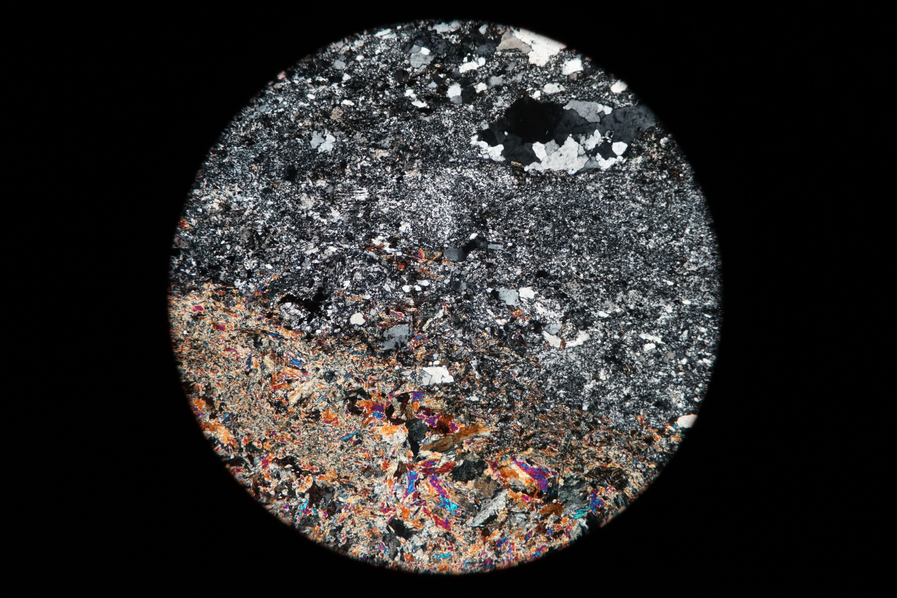 Circular microscopic image of rock structure.