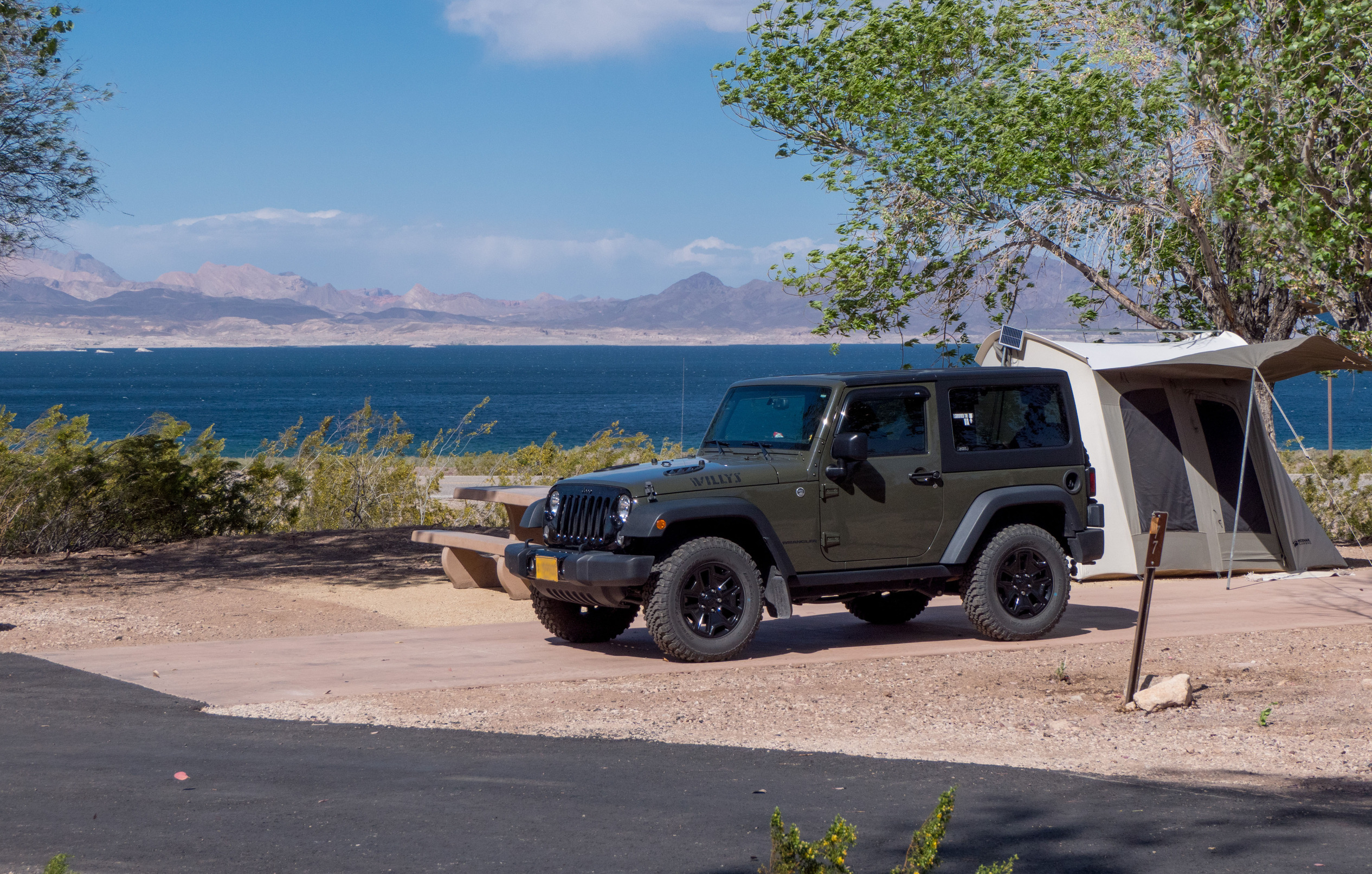 Campsite with Jeep and camp tent, Lake Mead and mountains in background