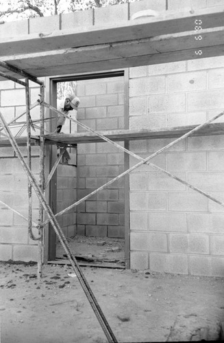 Man worker laying bricks during the construction of headquarters addition.