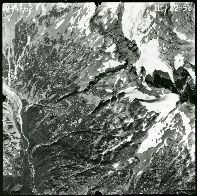 Black and white aerial photograph of glaciated mountain peaks and valleys.