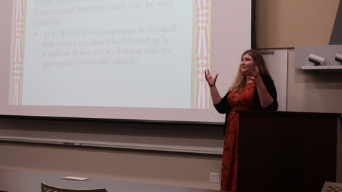 A person presenting from a projector.