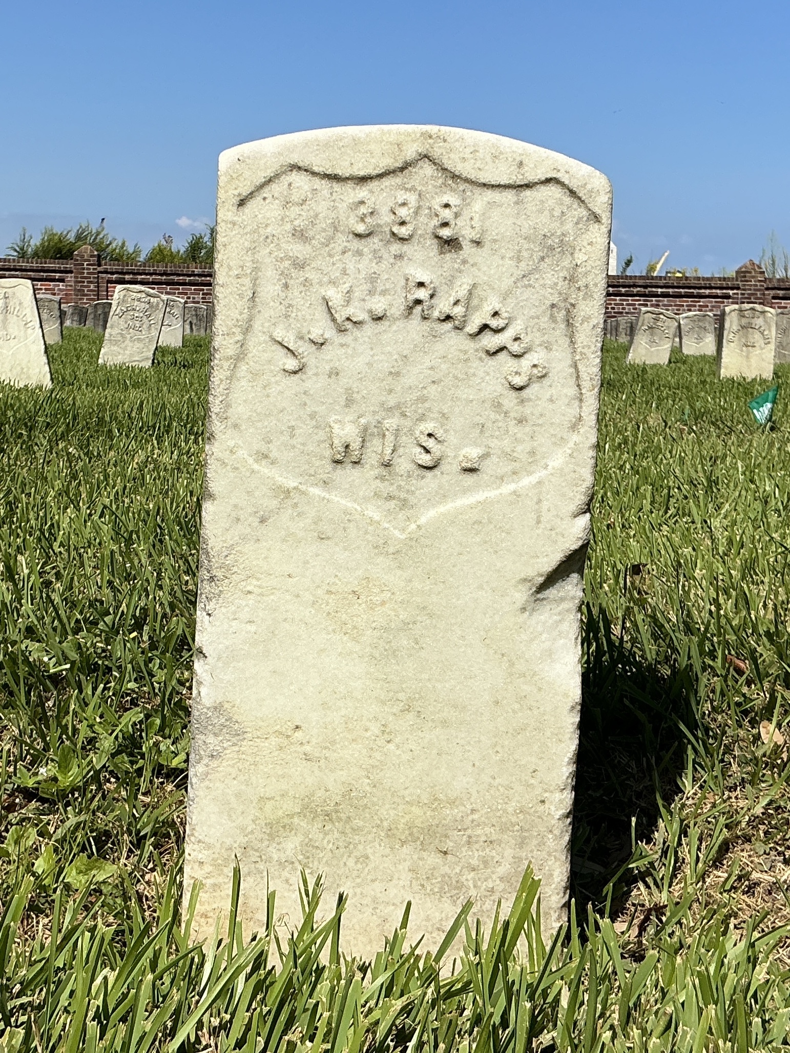 Front of historic upright marble headstone with recessed shield face.