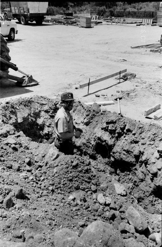 Man worker smiling during the construction of headquarters addition.