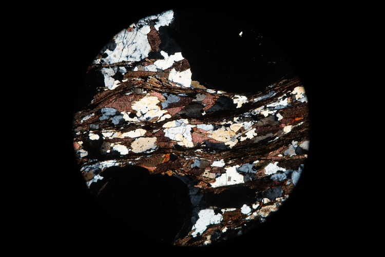 Circular microscopic image of rock structure.