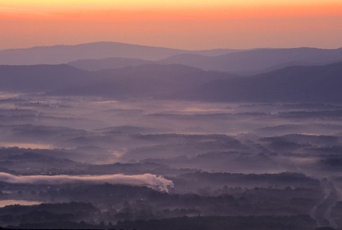 Mist settles in the ridges of a mountain valley at dawn.