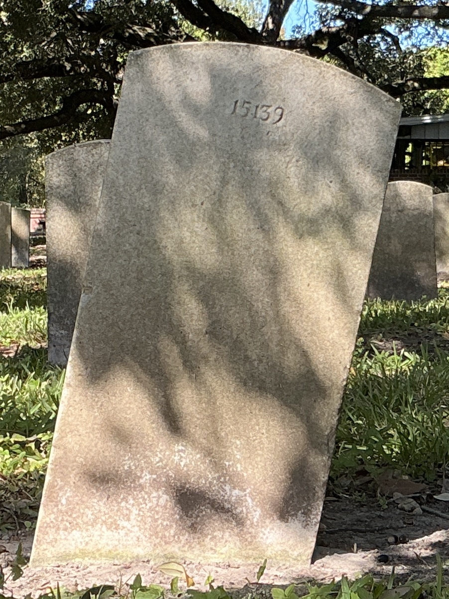 Back of historic upright marble headstone with recessed shield face.