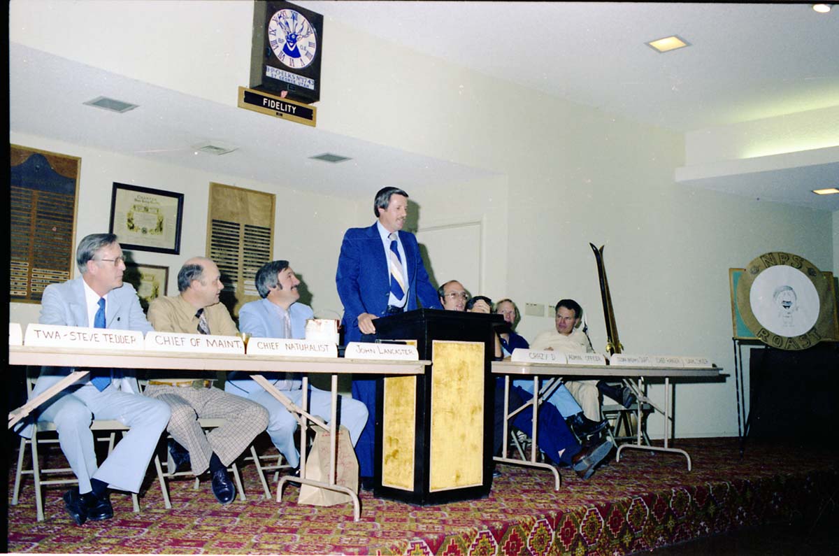 Color Photos of John Lancaster's farewell party at Elks Club in St. George, Utah. Speakers at roast in front of room: Pipe Spring National Monument Superintendent, TWA Steve Tedder, Chief of Maintenance, Chief Naturalist, John Lancaster, Crazy D, Administrative Officer, Cedar Breaks National Monument Superintendent, Chief Ranger, Unknown Skier.