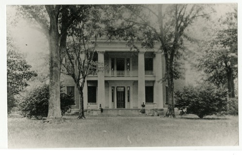 Greek revival mansion featuring four large columns, a front porch and second story balcony