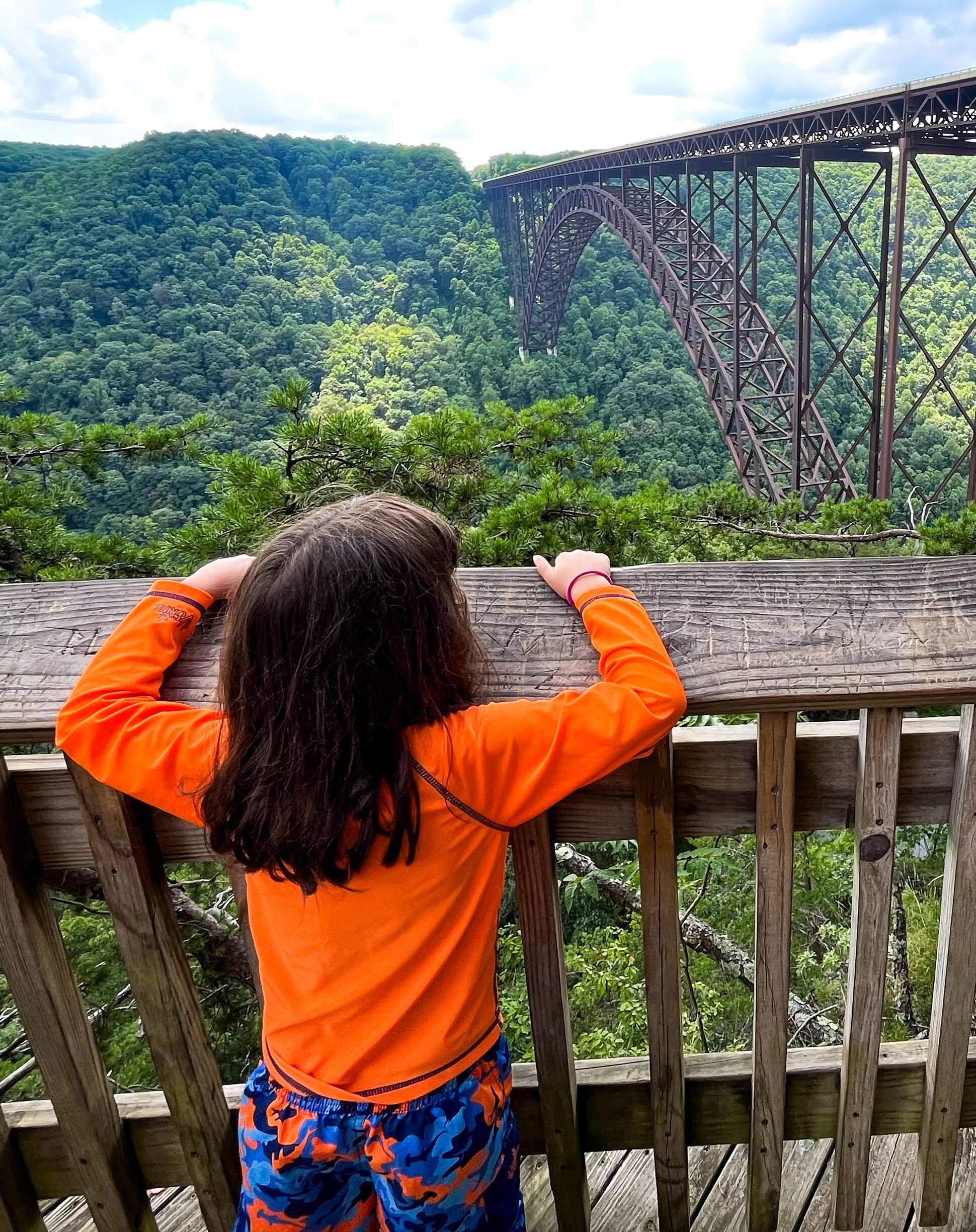 Kid looking a large bridge over a river