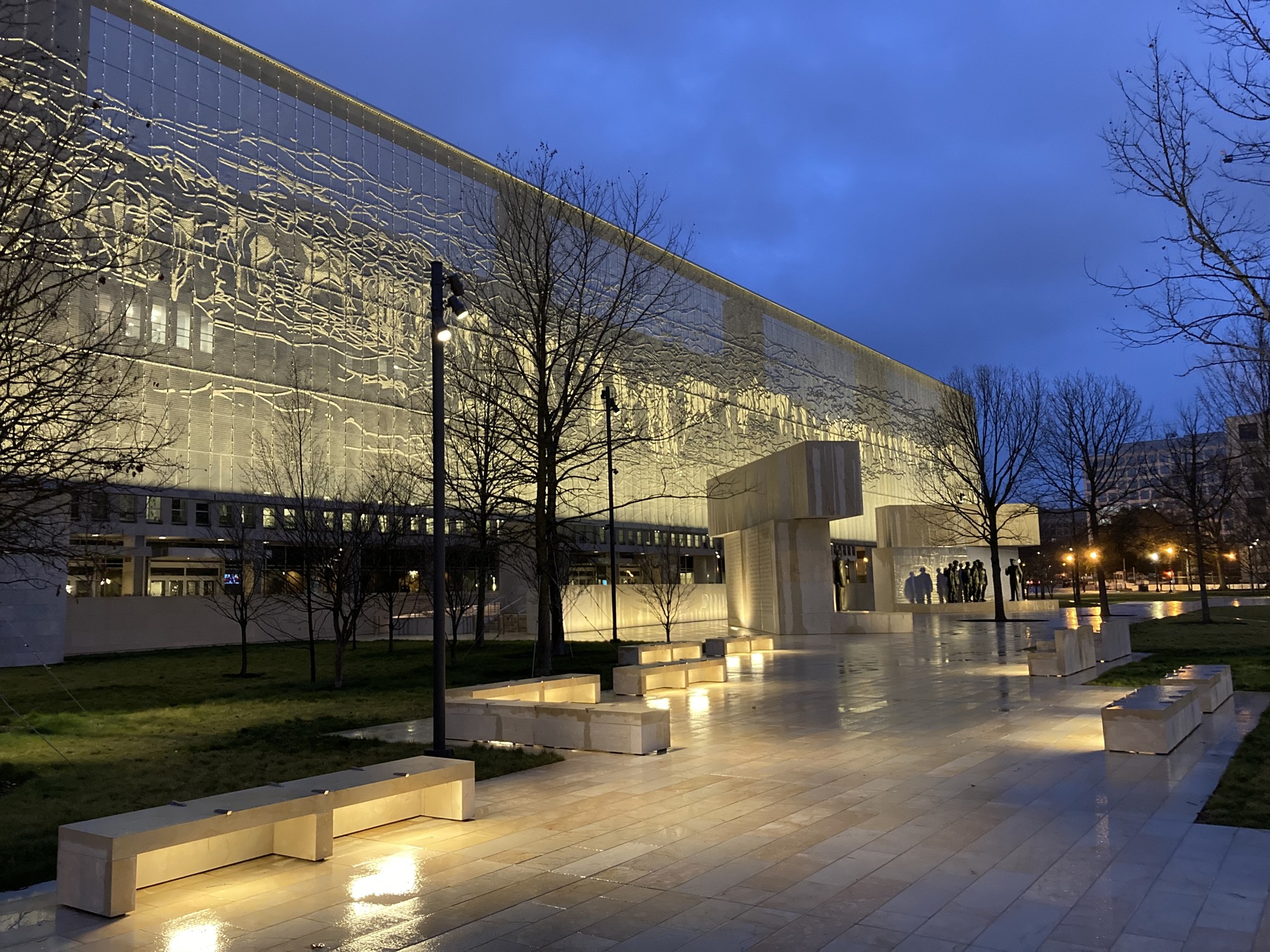 As dusk settles, lights underneath of stone benches and throughout the memorial brighten the Dwight D. Eisenhower Memorial at night. 