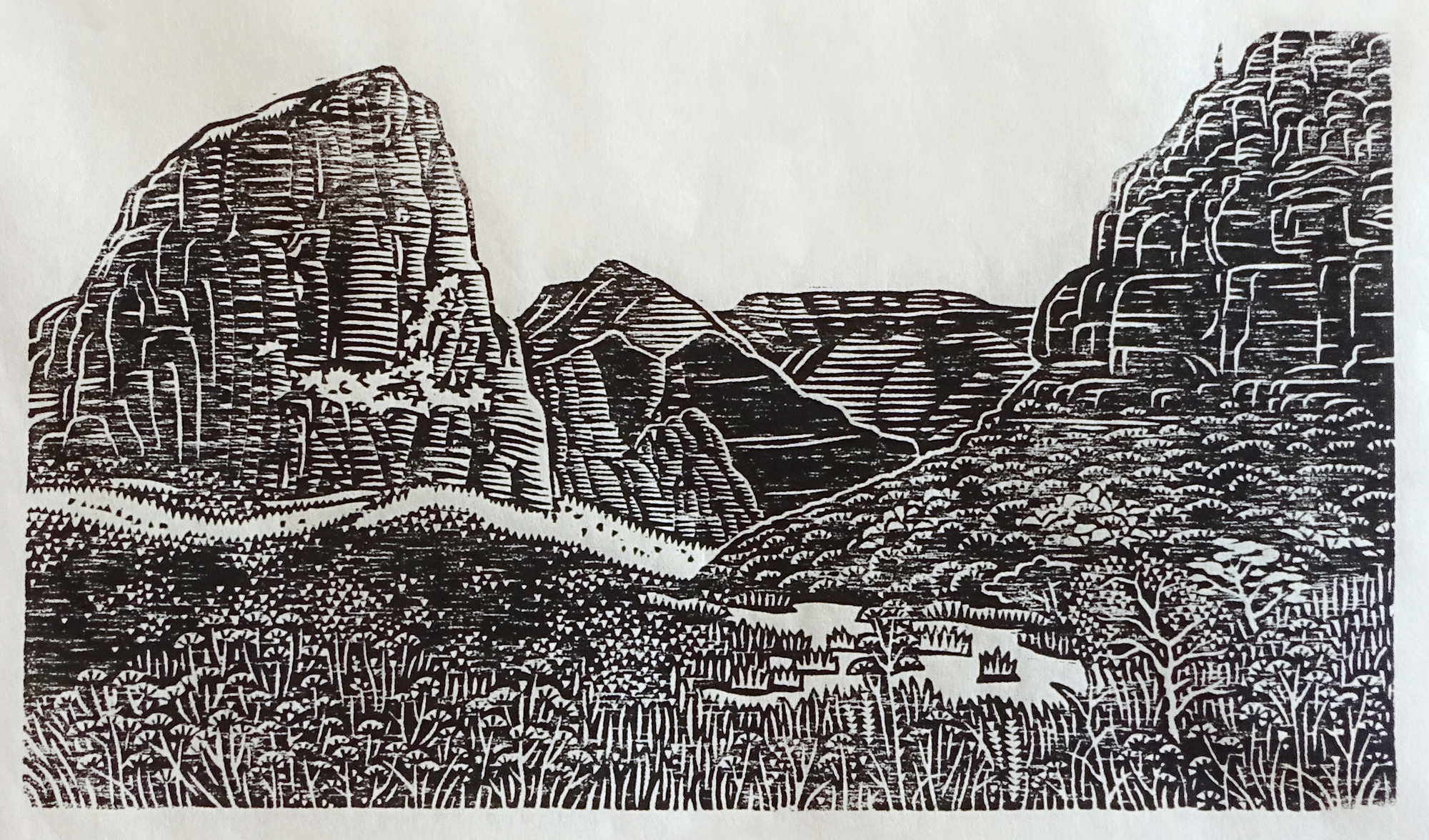 A texture-rich black-and-white image printed on paper using woodblock printing. In the foreground, a grassy field blends into a shrub-covered hillside. A rocky cliff face is seen above the hill. In the middleground, a large sandstone peak stands above surrounding vegetation. In the background, tall flat-topped cliffs stand before a white sky.
