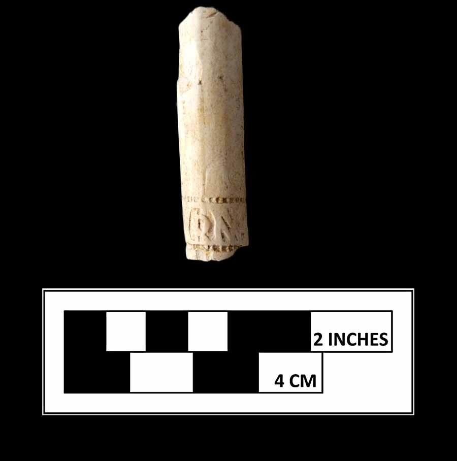 A white clay tobacco pipe stem with the initials RW marked near the bottom.