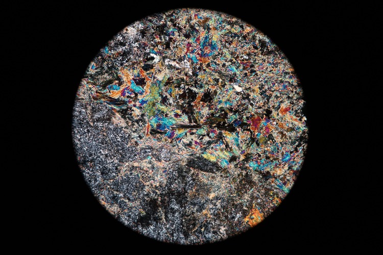 Circular microscopic image of rock structure.