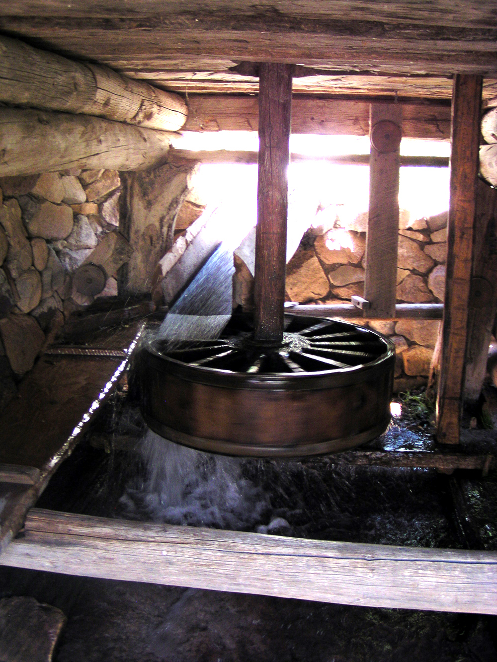 A water wheel in a wooden structure.