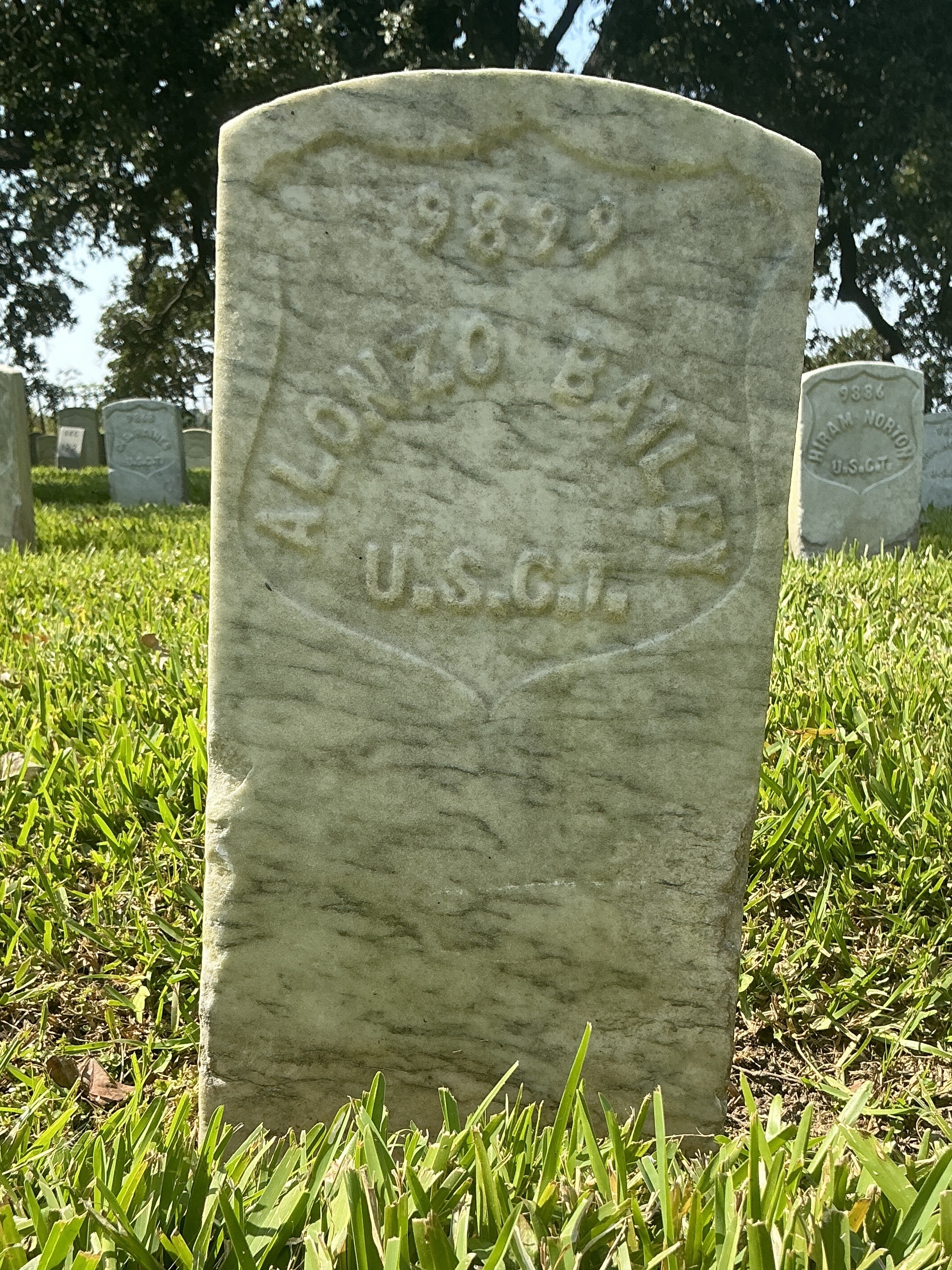 Front of historic upright marble headstone with recessed shield face.