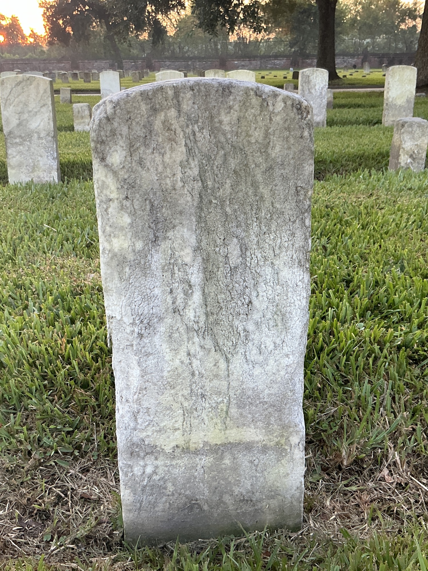 Back of historic upright marble headstone with recessed shield face.