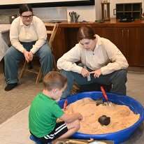 Union soldier and visitors digging in the archeology station.