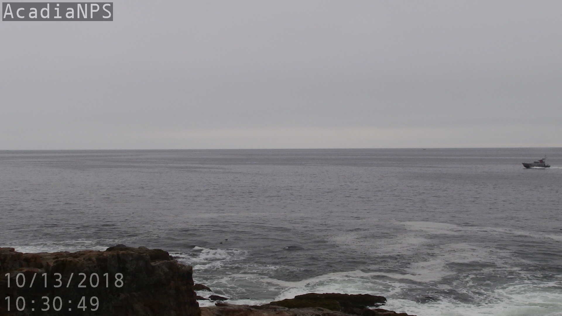 Boat speeds into frame in middle distance
