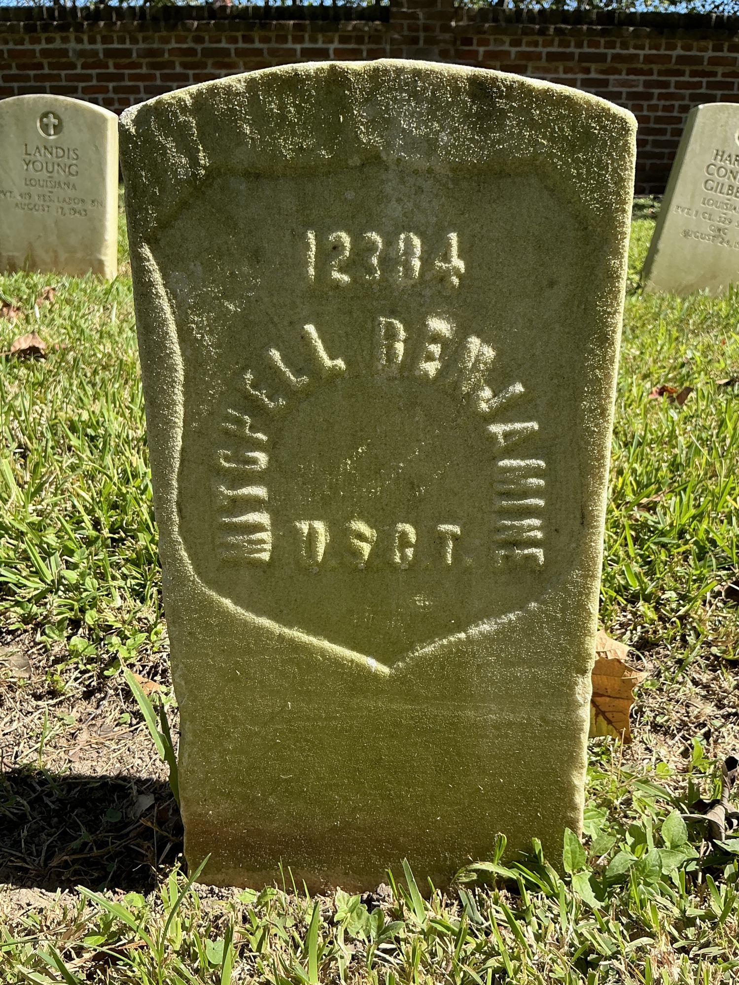 Front of historic upright marble headstone with recessed shield face.