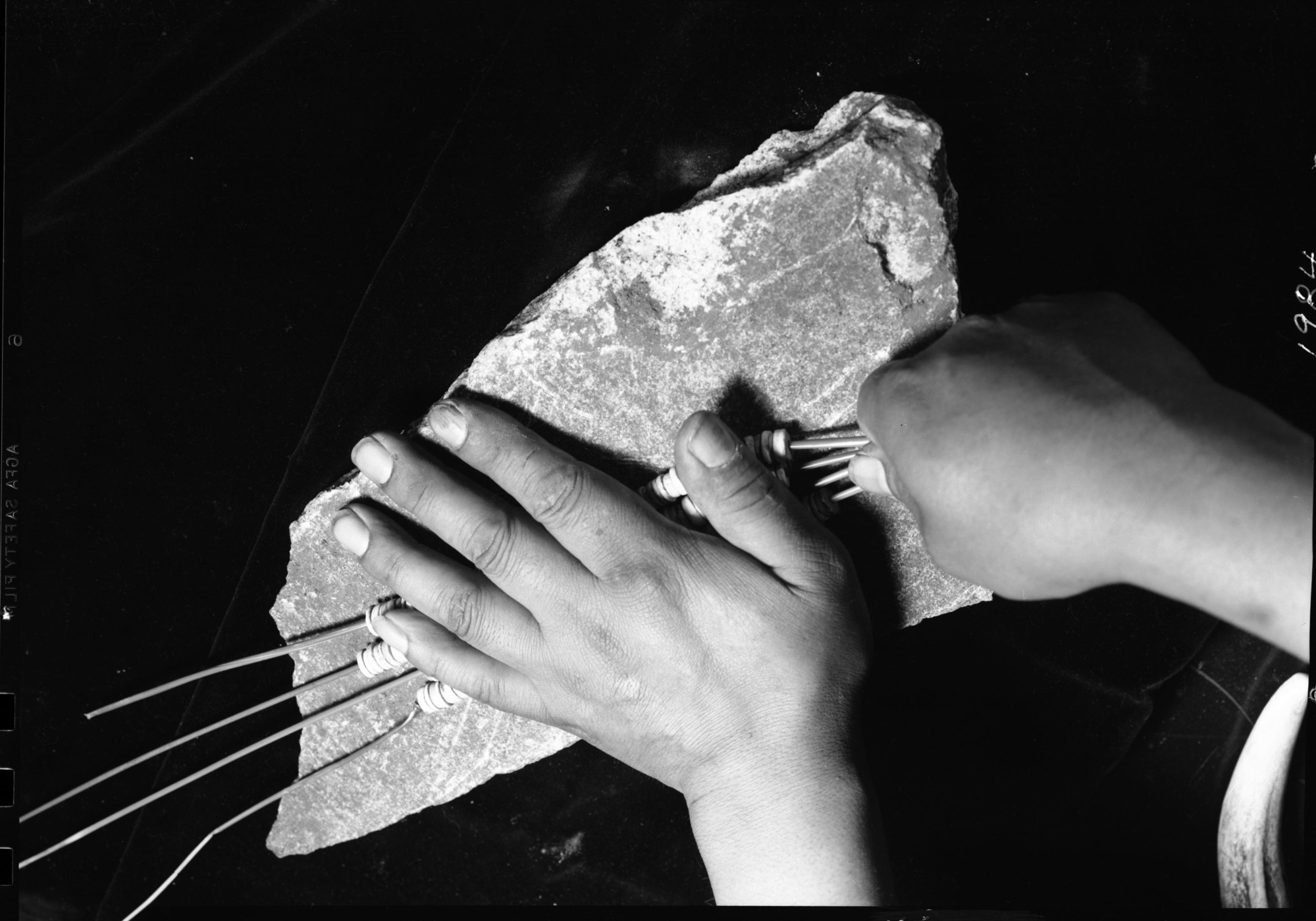Le-me showing method of grinding clambshell beads. [(Photo mounted upside down) - in "Monthly Supt. Reports" April 1940].
