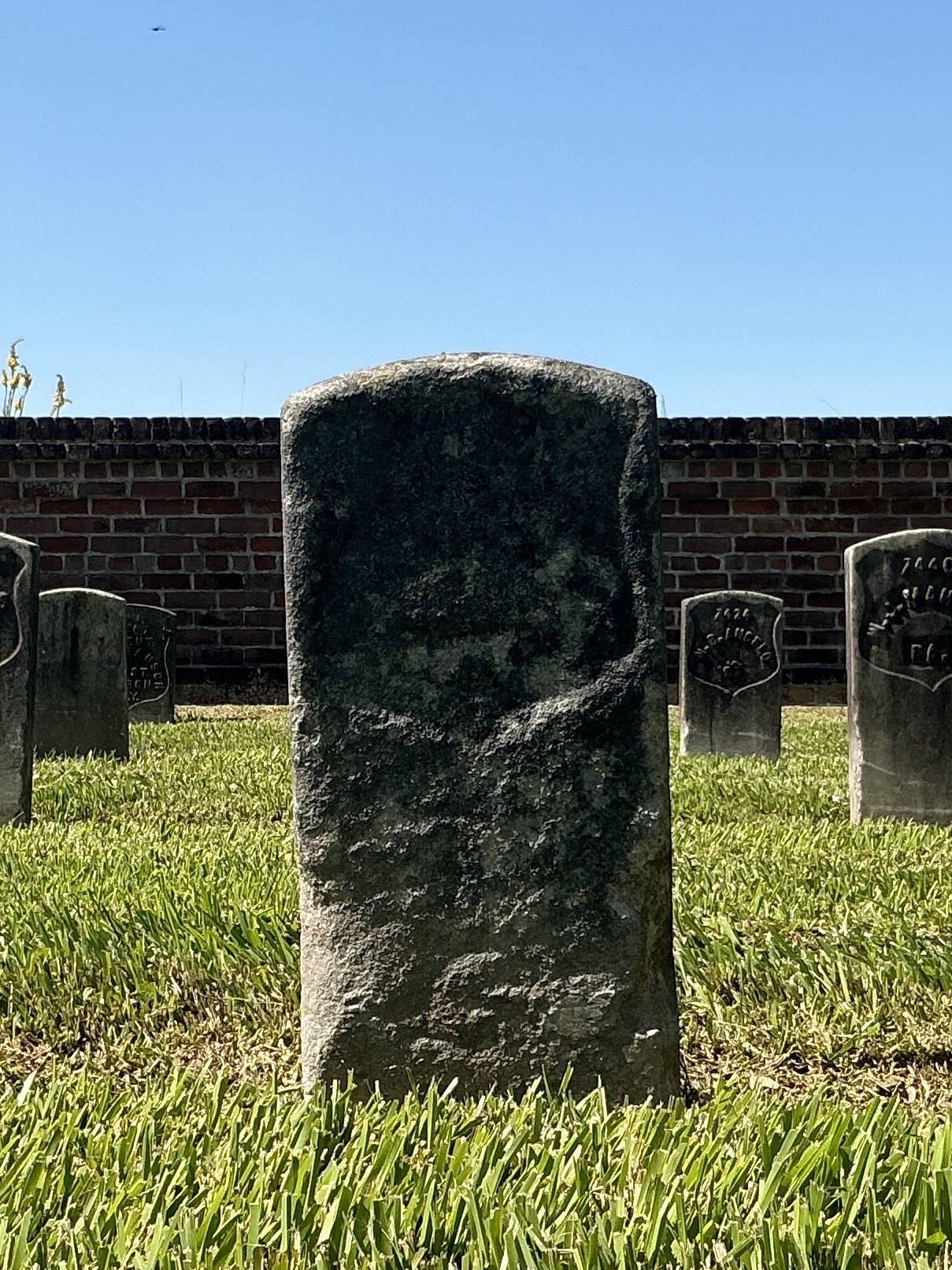 Front of historic upright marble headstone with recessed shield face.
