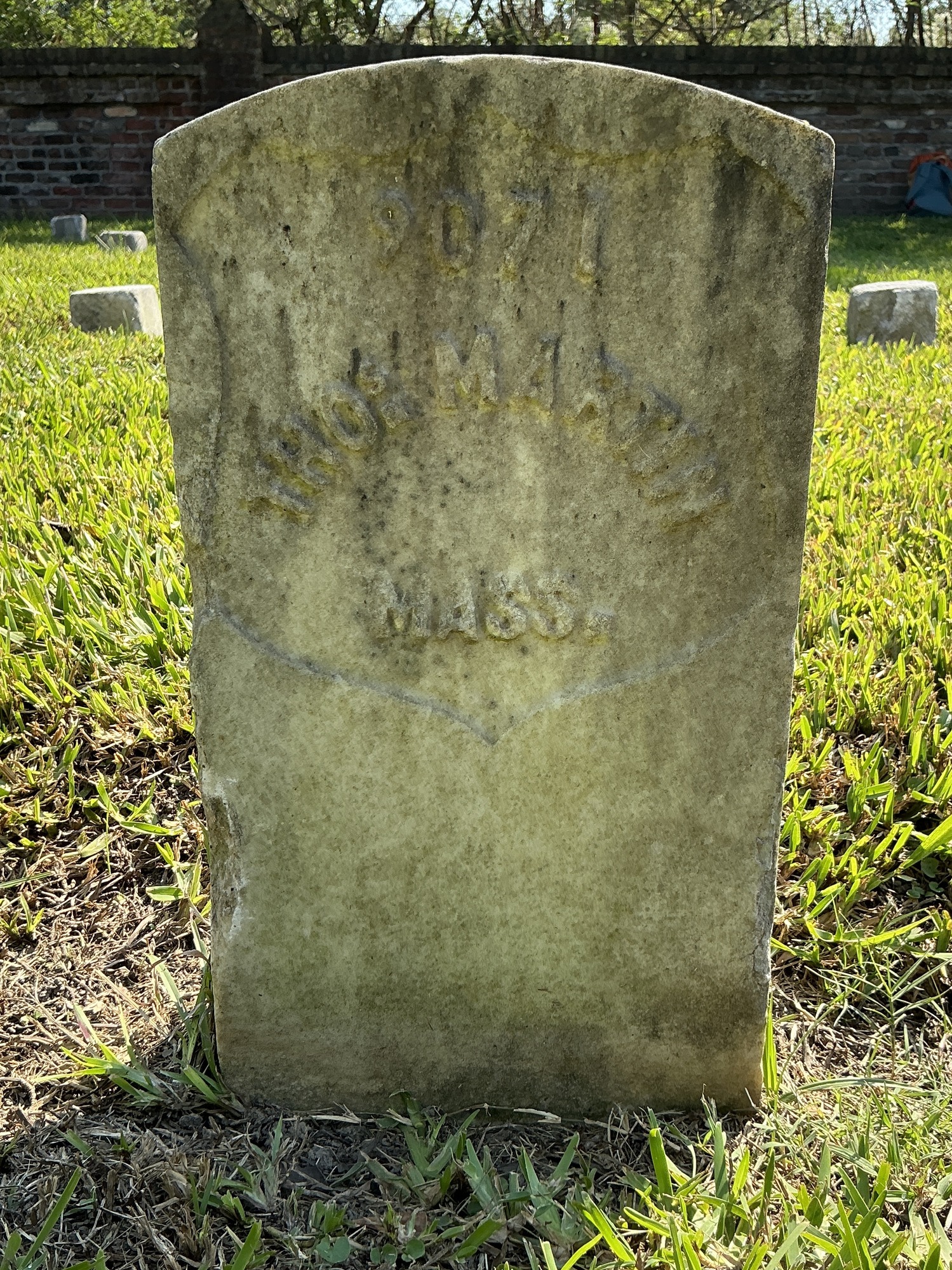 Front of historic upright marble headstone with recessed shield face.