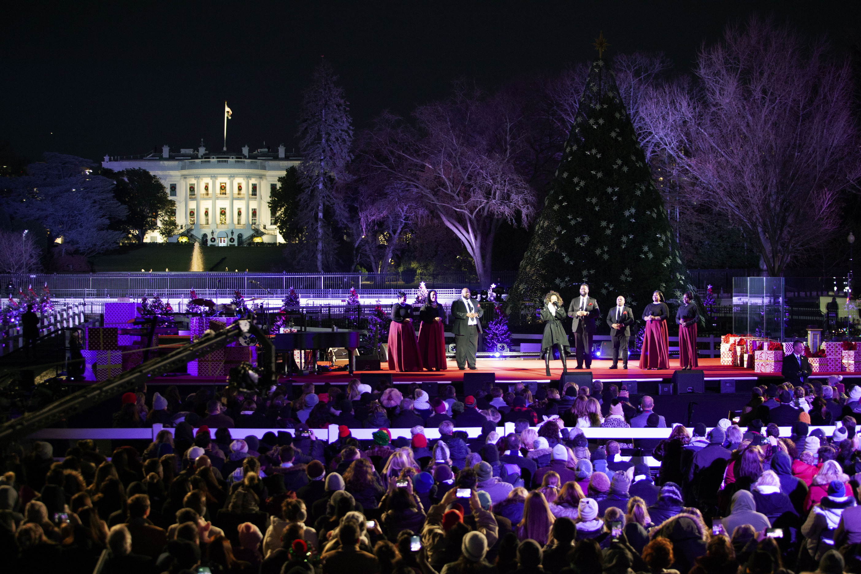 Spensha Baker and backup vocalists perform at the National Christmas Tree Lighting with the National Christmas Tree and White House behind them