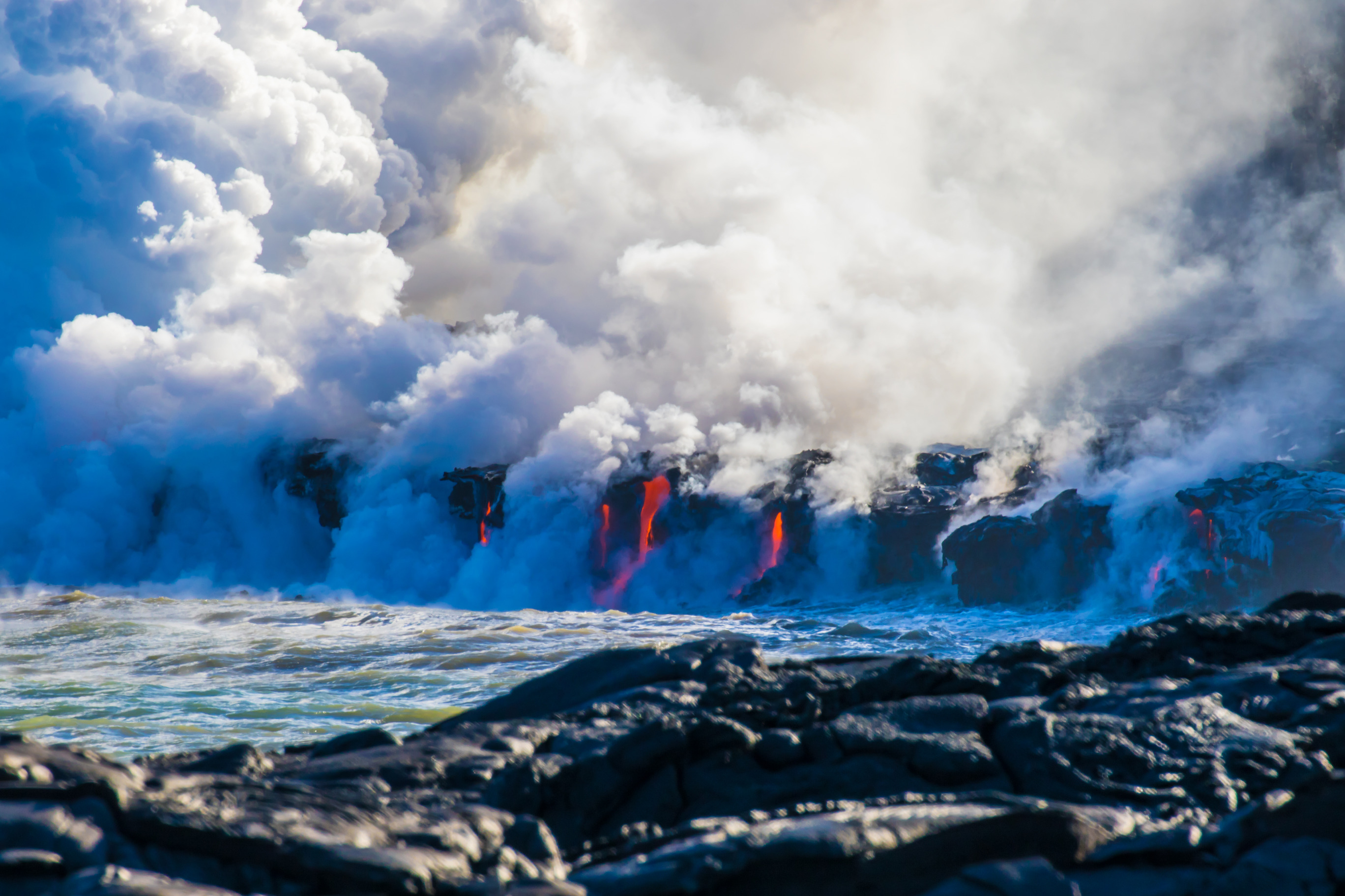 Steaming lava enters the ocean from cliffs