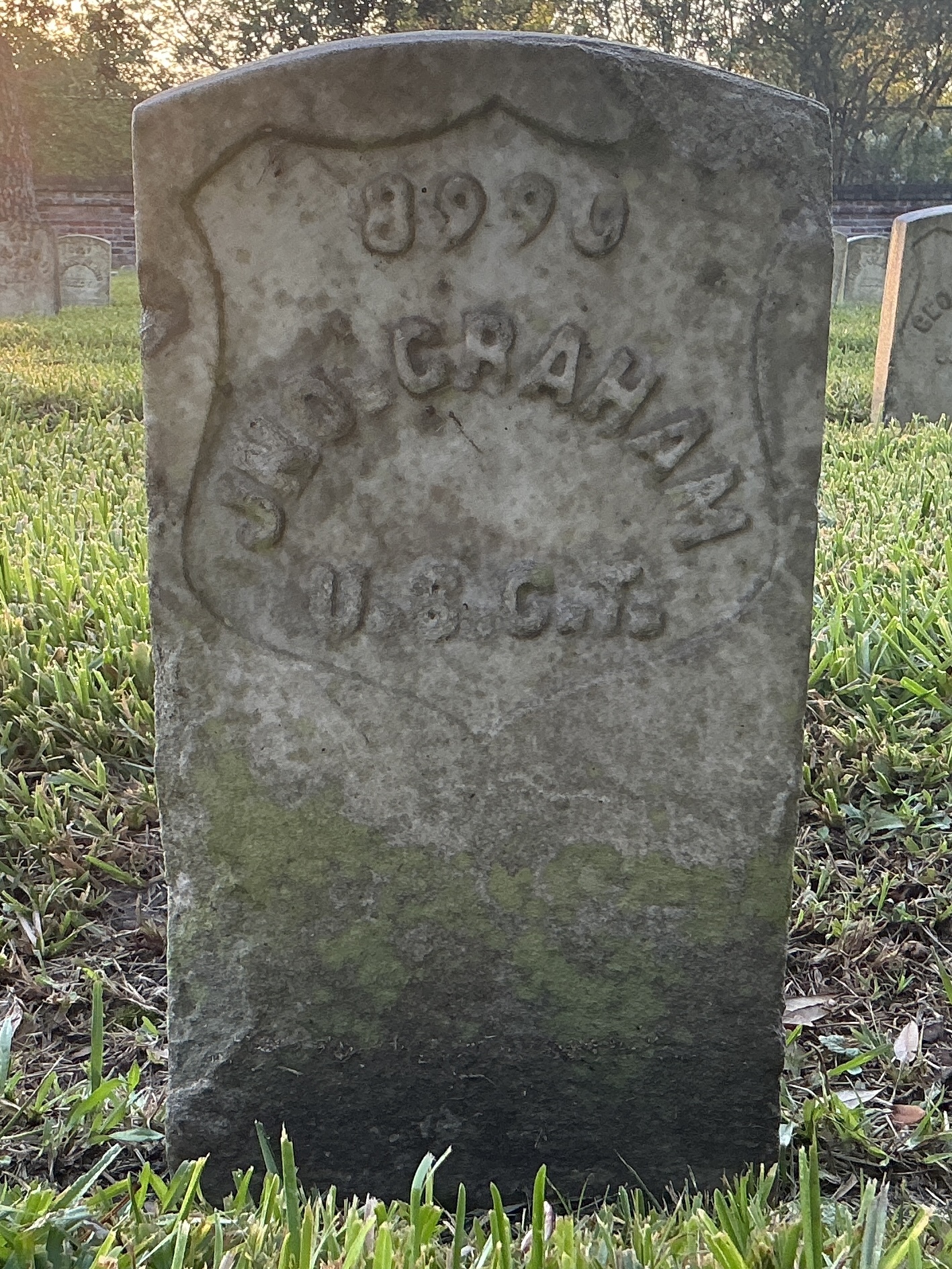 Front of historic upright marble headstone with recessed shield face.