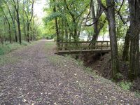 A trail with a wooden bridge.