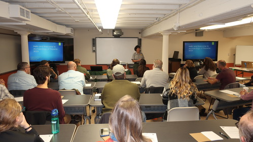 people in a classroom watching a woman speak.