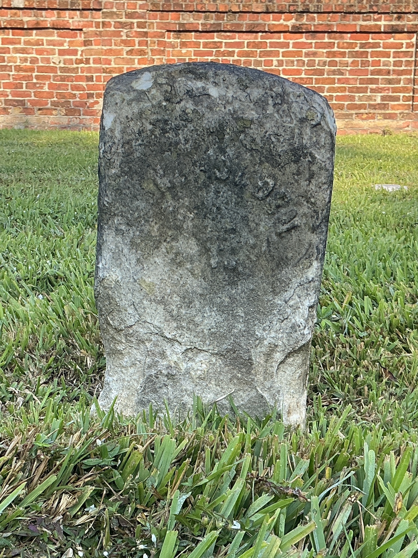 Front of historic upright marble headstone with recessed shield face.